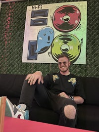 a man sitting on a couch next to a poster